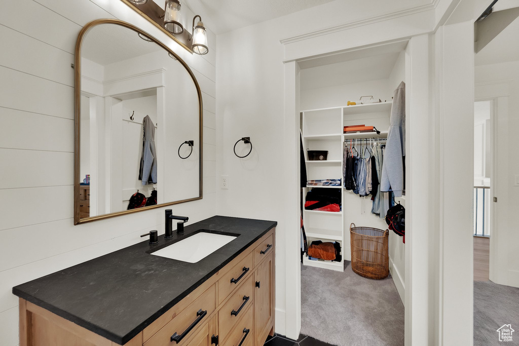 Bathroom with vanity and a walk in closet