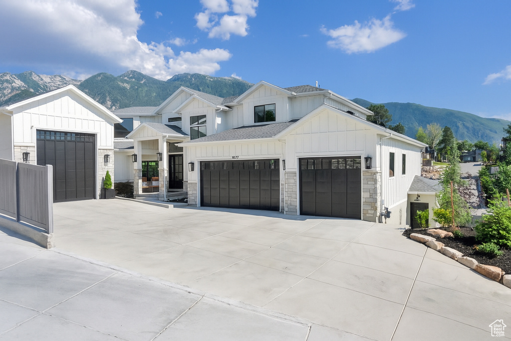 Modern farmhouse style home featuring board and batten siding, a mountain view, concrete driveway, and an attached garage