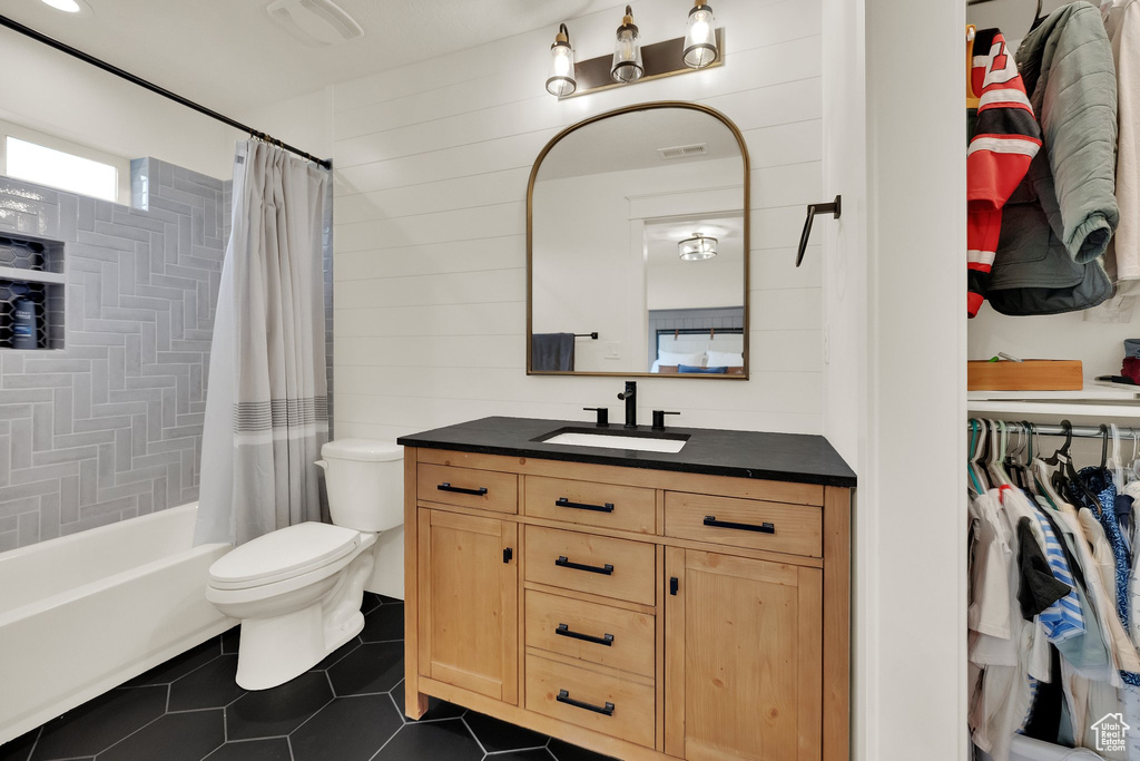 Full bathroom featuring vanity, tile patterned floors, shower / bathtub combination with curtain, and wood walls