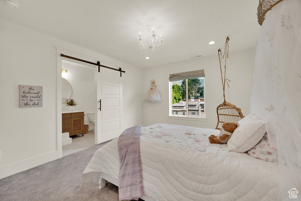 Bedroom featuring a barn door, carpet, recessed lighting, a chandelier, and connected bathroom