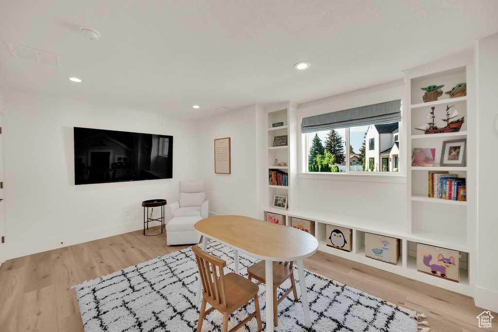Playroom featuring wood finished floors, recessed lighting, and built in shelves