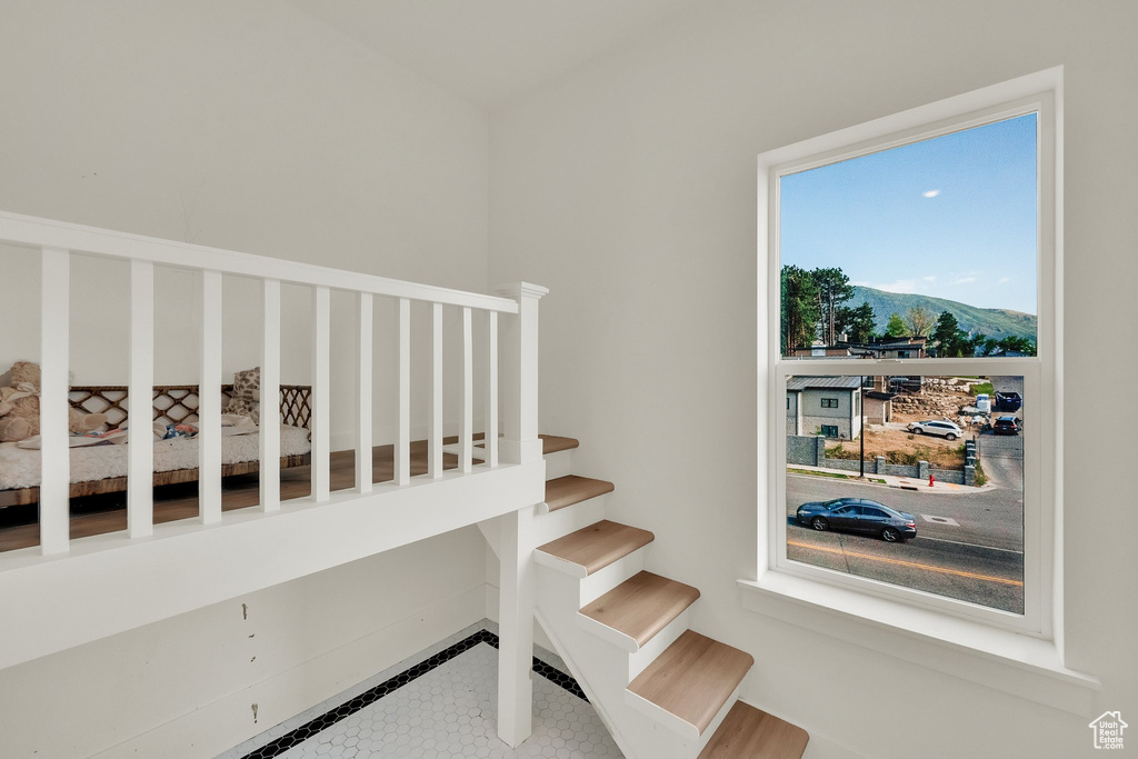 Staircase featuring inlaid floor details, a mountain view, and tile patterned flooring