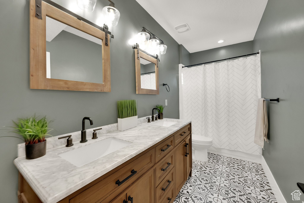 Full bath with double vanity, tile patterned flooring, and a shower with curtain