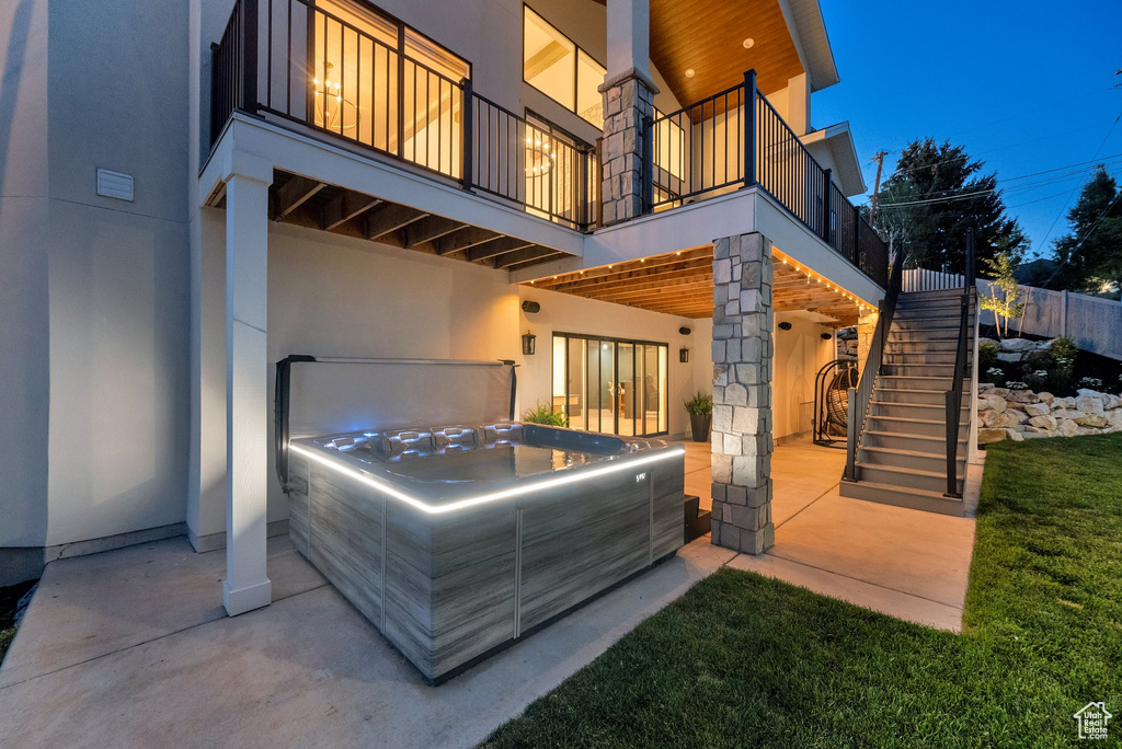 Patio / terrace with a hot tub, stairs, a patio, and a garage