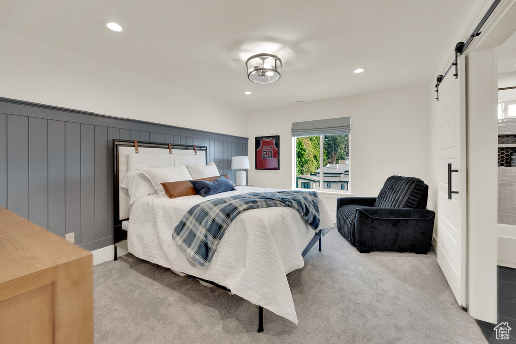 Bedroom featuring a barn door, carpet floors, and recessed lighting