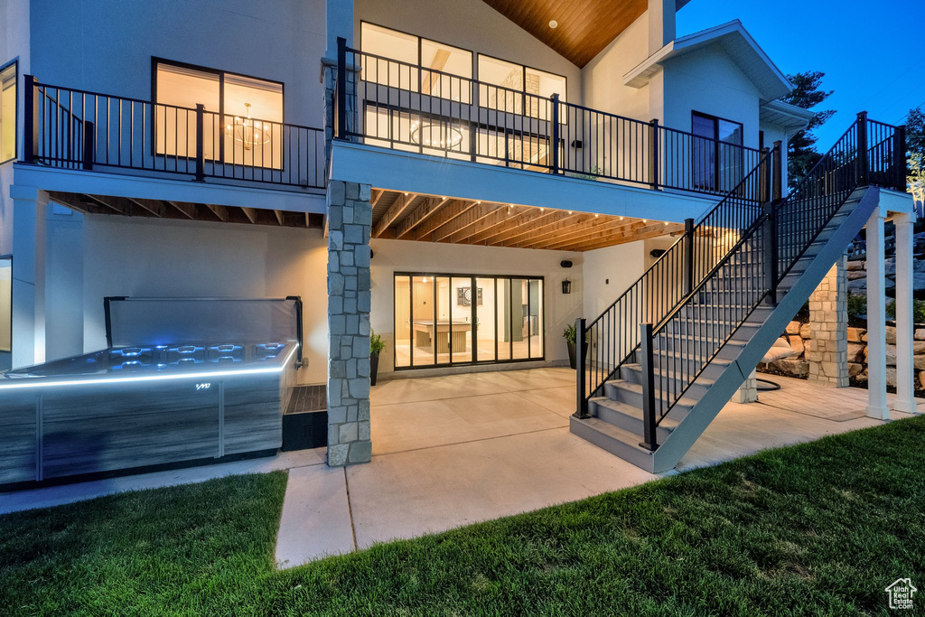 Back of property featuring stucco siding, a patio, and stairs