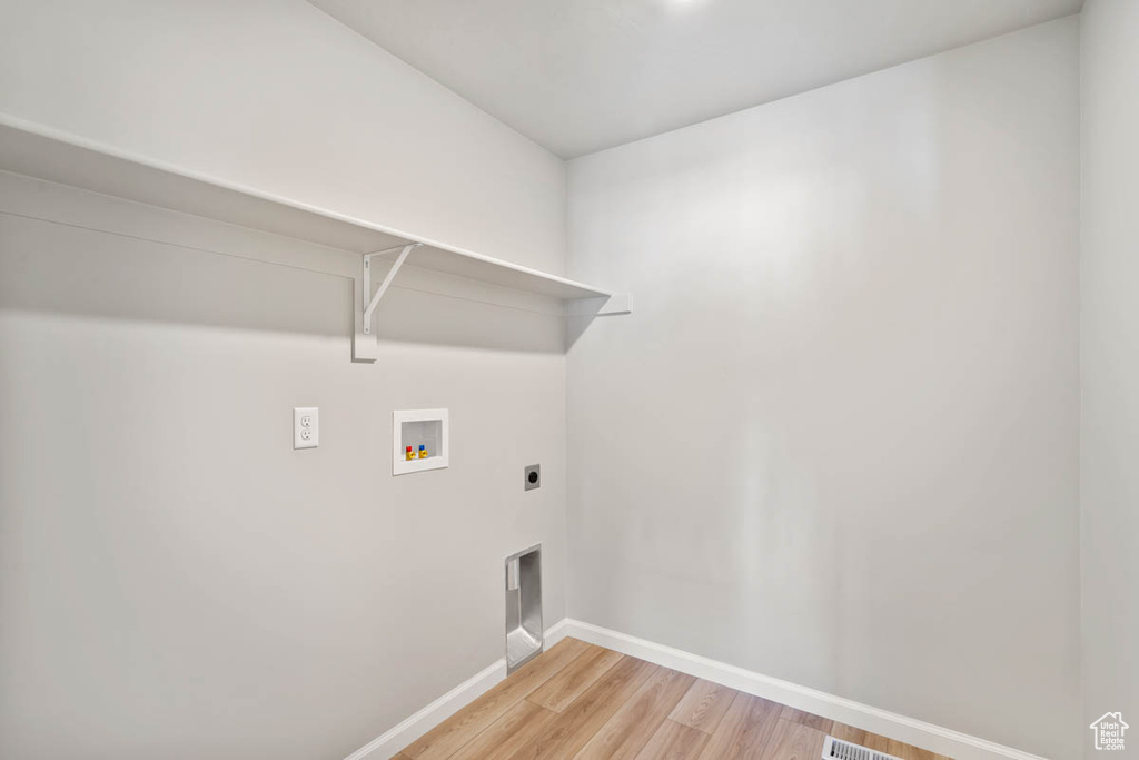 Washroom featuring hookup for a washing machine, light wood-type flooring, and electric dryer hookup