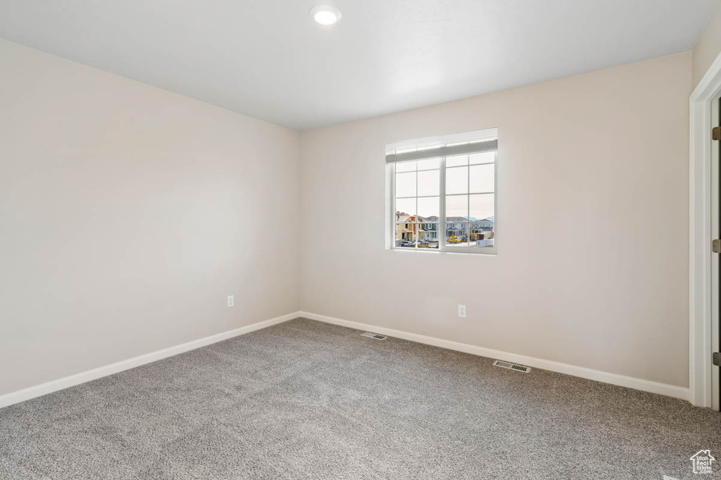 Carpeted empty room featuring baseboards and recessed lighting