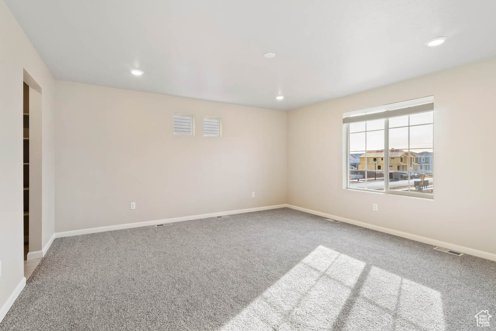 Carpeted spare room featuring recessed lighting and baseboards