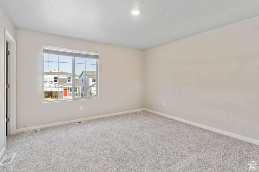 Carpeted empty room with baseboards and recessed lighting