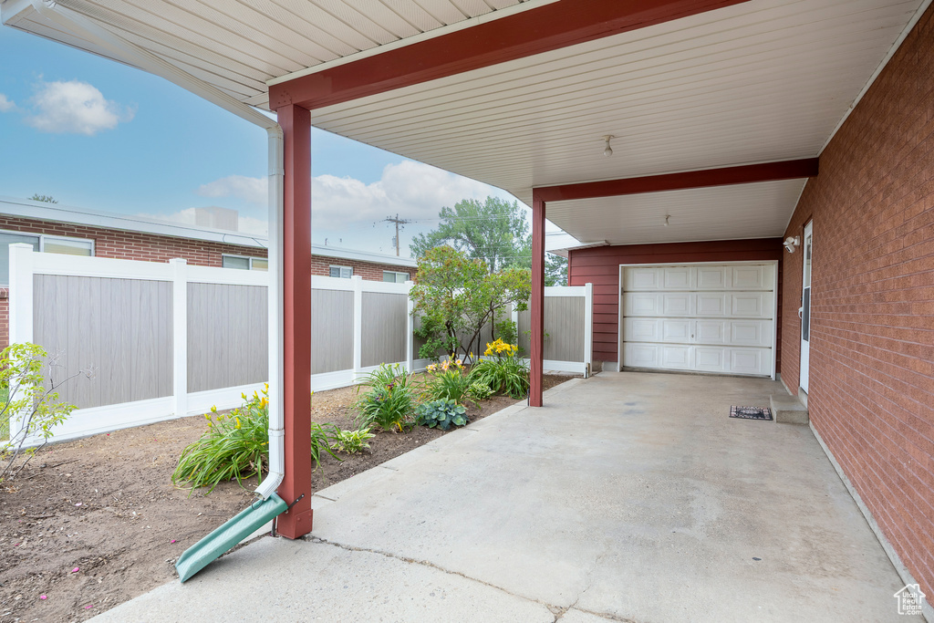 View of patio featuring a garage and driveway