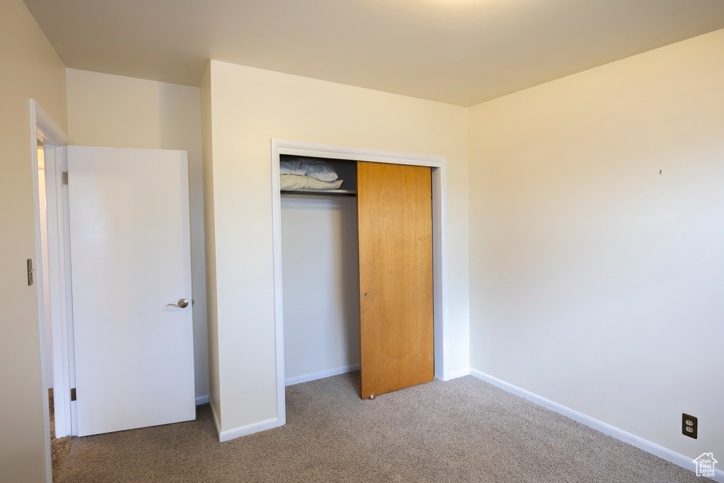 Unfurnished bedroom with carpet floors and a closet