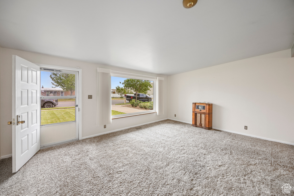 Spare room featuring healthy amount of natural light and carpet floors