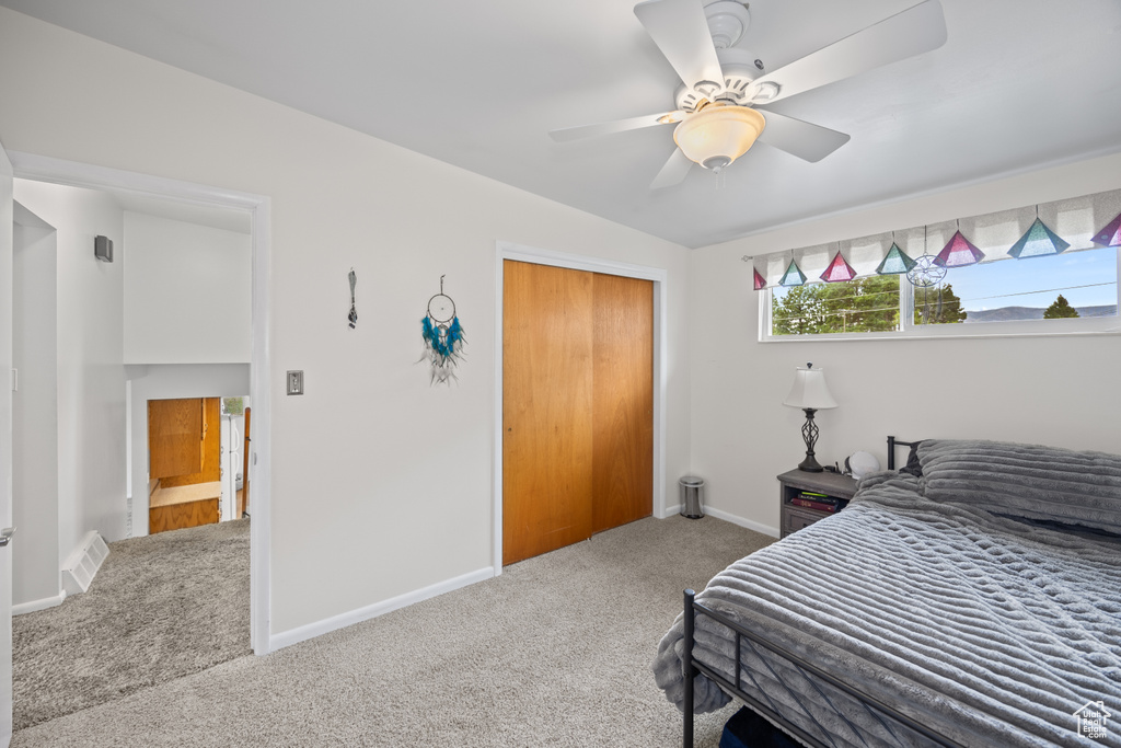 Bedroom with carpet, a closet, and a ceiling fan