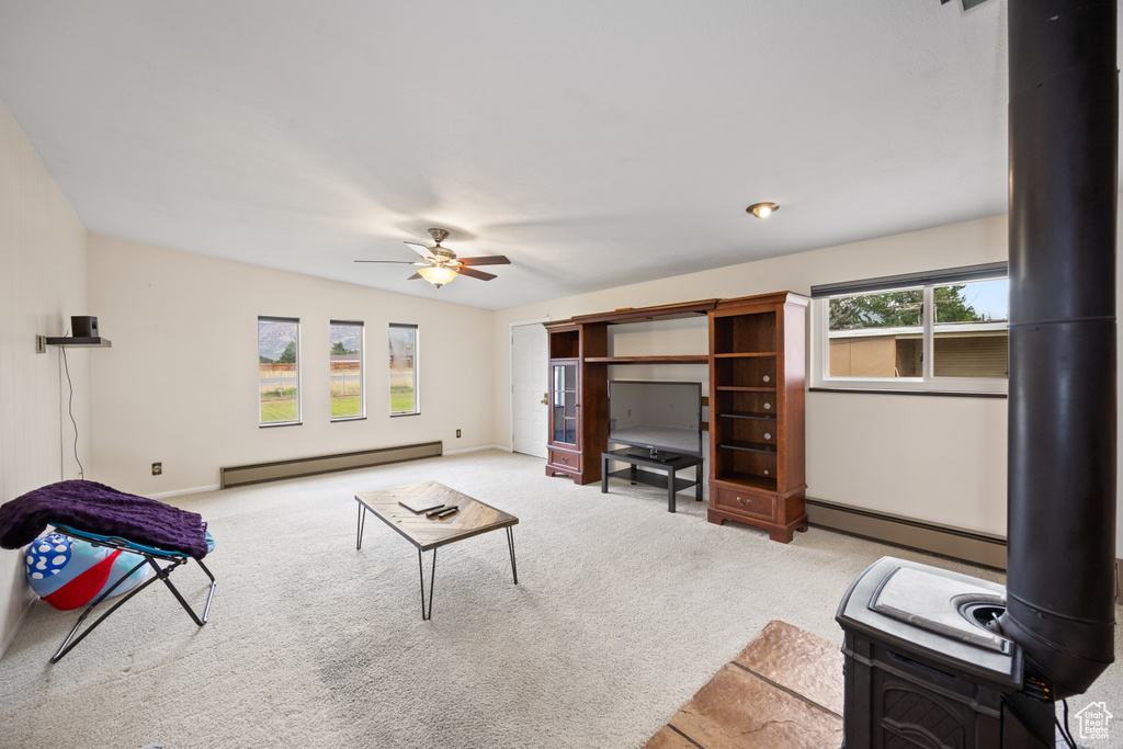 Unfurnished living room with baseboard heating, a baseboard radiator, ceiling fan, and carpet