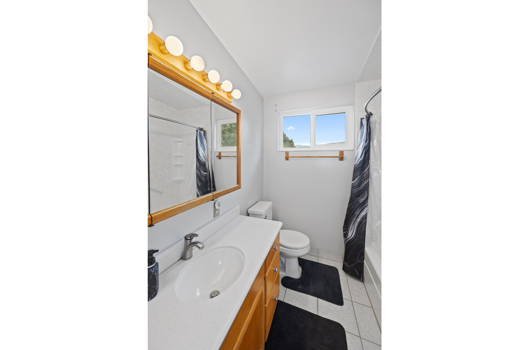 Bathroom featuring vanity, tile patterned flooring, and shower / bath combo with shower curtain