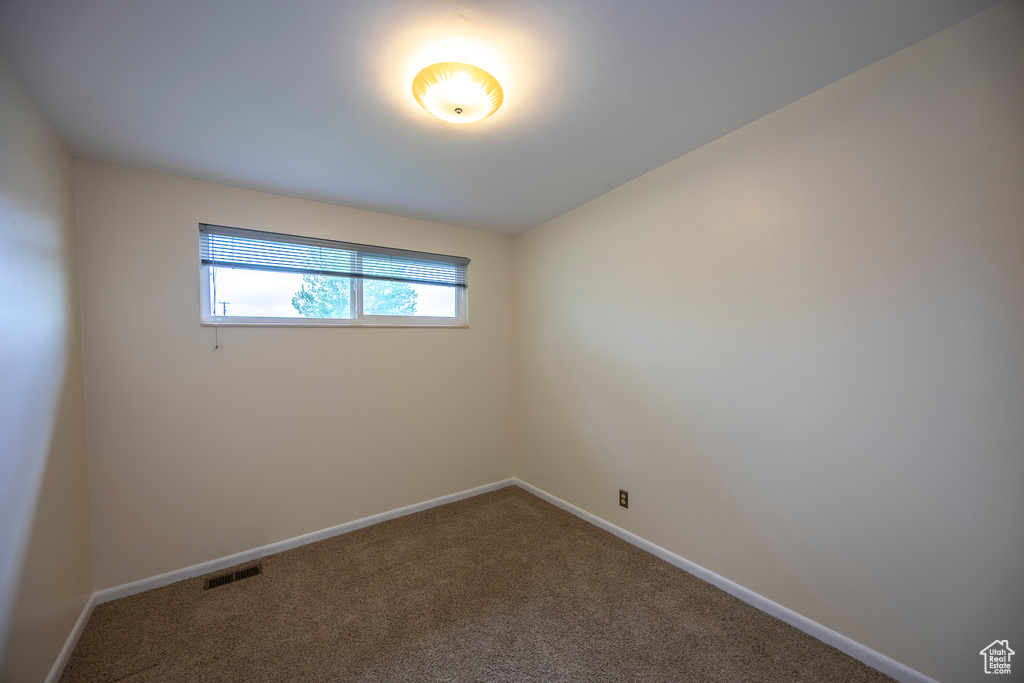 Carpeted empty room featuring baseboards