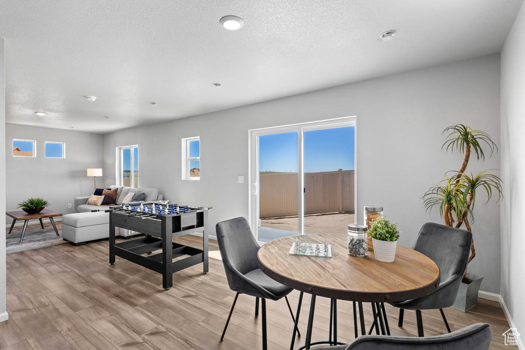 Dining room with light wood-style flooring and a textured ceiling
