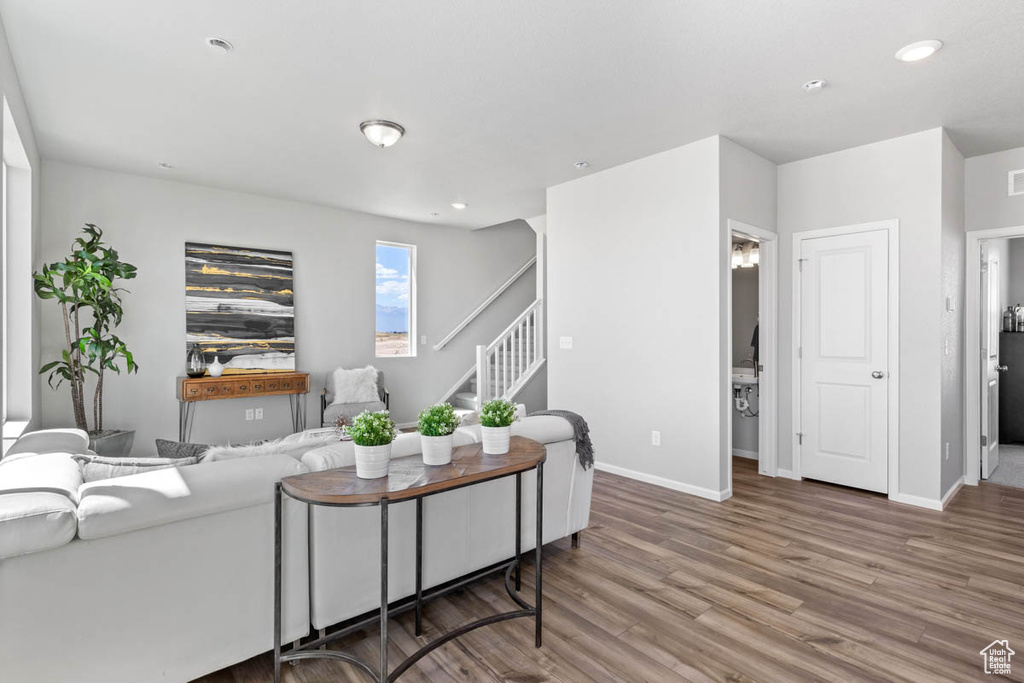 Living area featuring stairway, wood finished floors, and recessed lighting