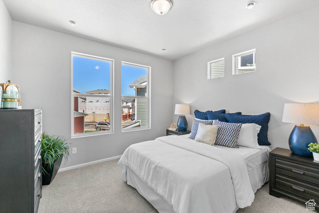 Bedroom with light colored carpet and baseboards