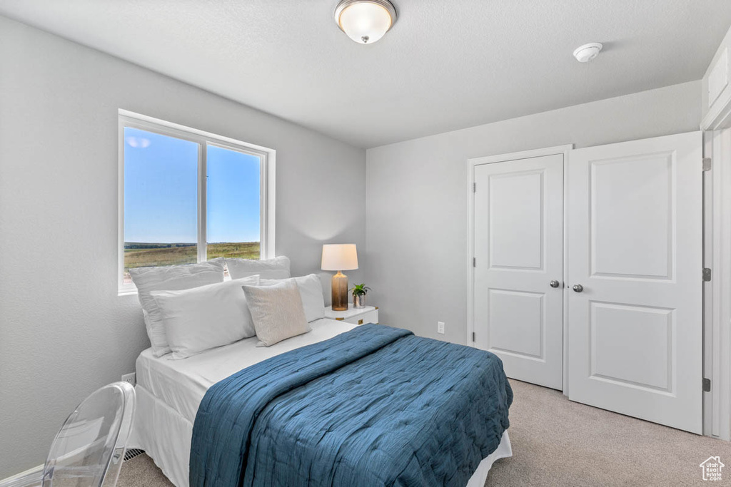 Bedroom featuring light colored carpet