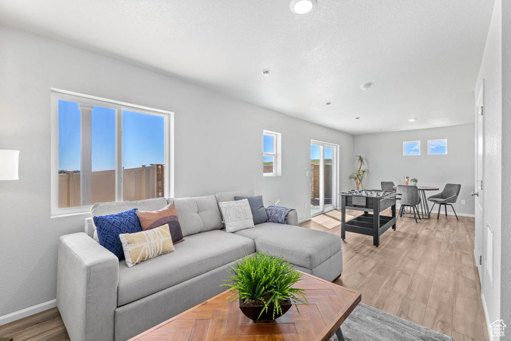 Living area featuring light wood-style floors and recessed lighting