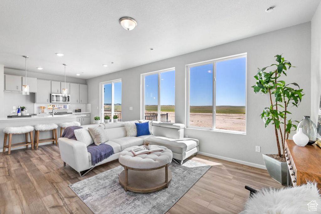 Living room featuring healthy amount of natural light, light wood-style flooring, and recessed lighting