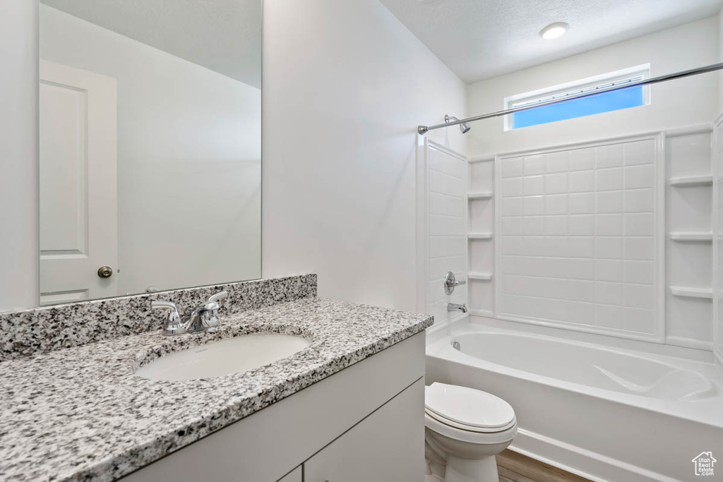 Full bathroom with bathtub / shower combination, vanity, and wood finished floors