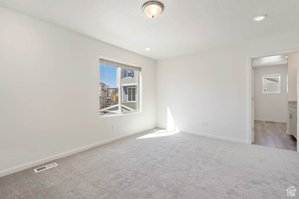 Carpeted spare room with healthy amount of natural light and recessed lighting