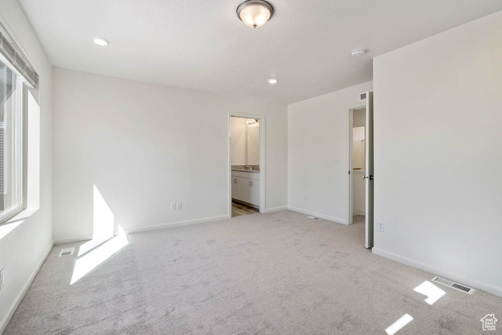 Unfurnished bedroom with carpet, connected bathroom, and recessed lighting
