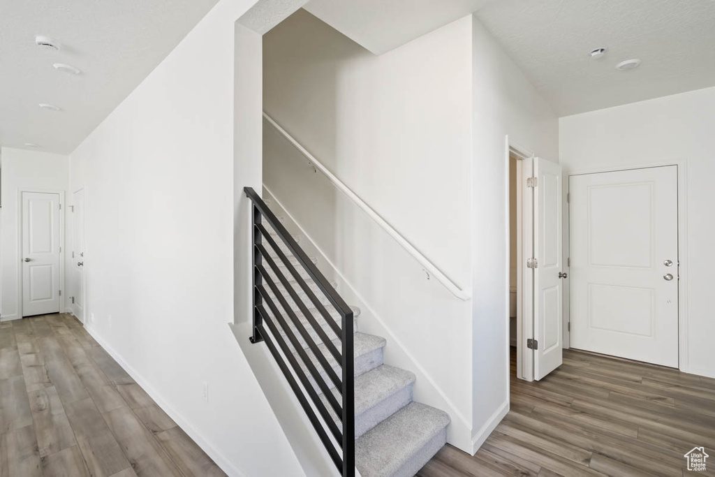 Stairs featuring wood finished floors