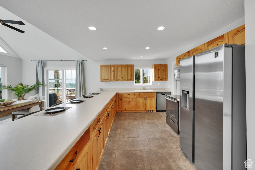 Kitchen featuring stainless steel appliances, recessed lighting, light countertops, and a ceiling fan