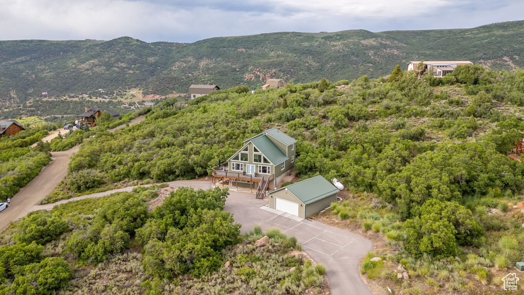 Bird\'s eye view of a mountain backdrop and a heavily wooded area