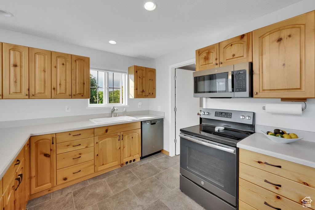 Kitchen with stainless steel appliances, recessed lighting, light countertops, and light brown cabinetry