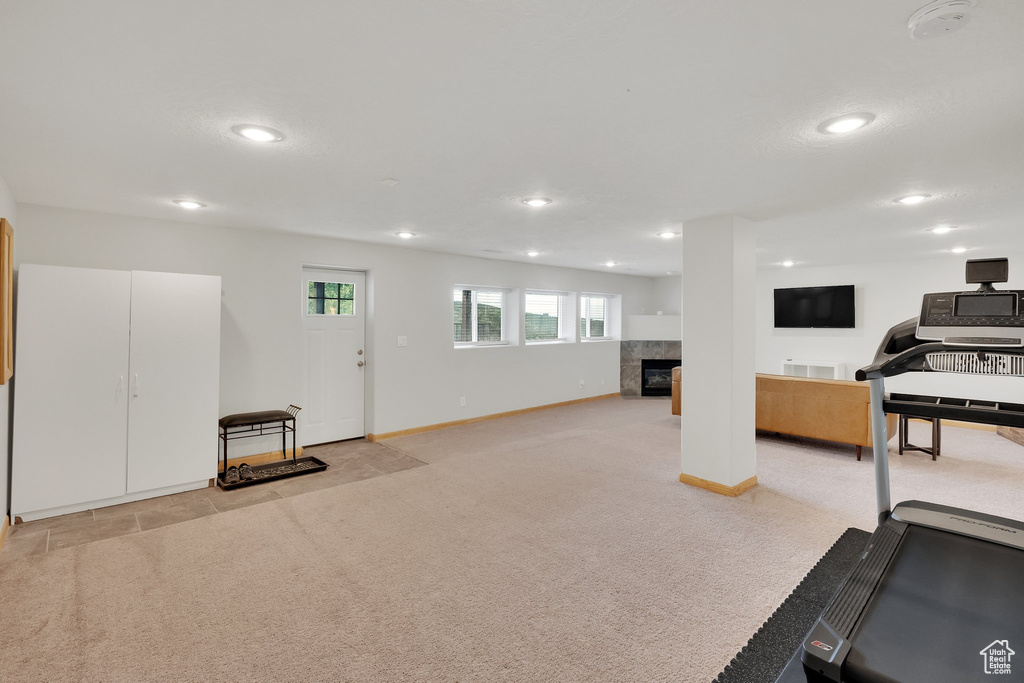 Exercise room featuring recessed lighting, a fireplace, and light carpet