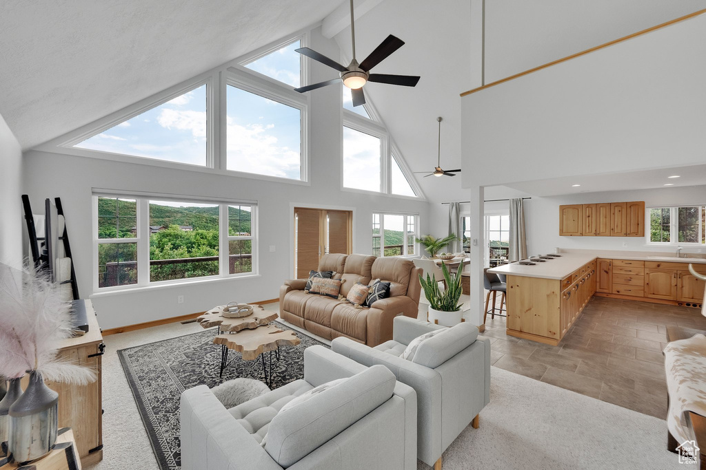 Living room with ceiling fan, plenty of natural light, high vaulted ceiling, beamed ceiling, and recessed lighting