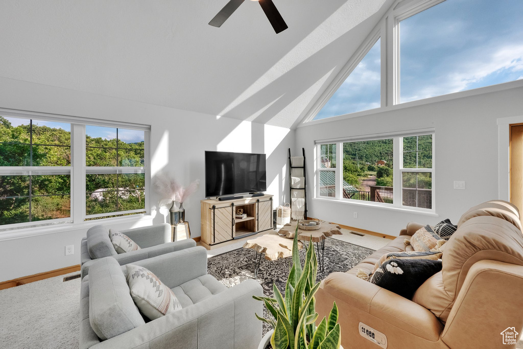 Living area featuring ceiling fan and high vaulted ceiling