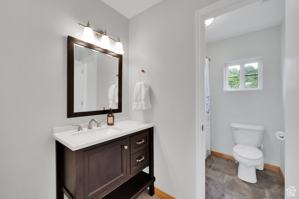 Full bath with vanity and stone finish floors