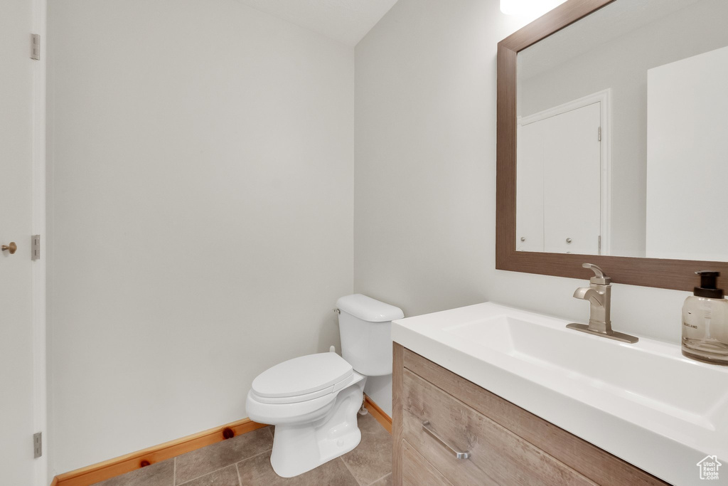 Half bath with vanity and tile patterned flooring