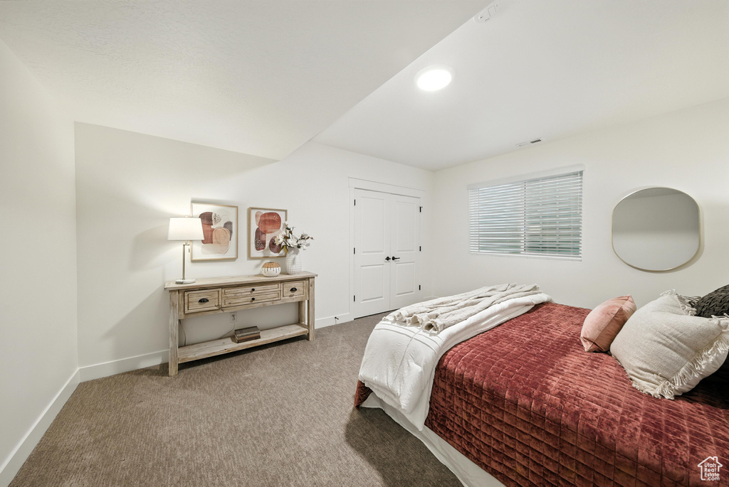 Carpeted bedroom featuring baseboards and a closet