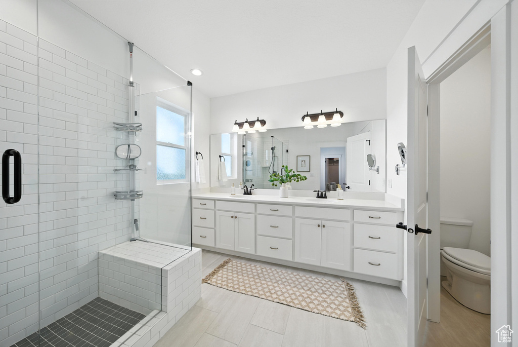 Bathroom with a stall shower, double vanity, tile patterned flooring, and recessed lighting