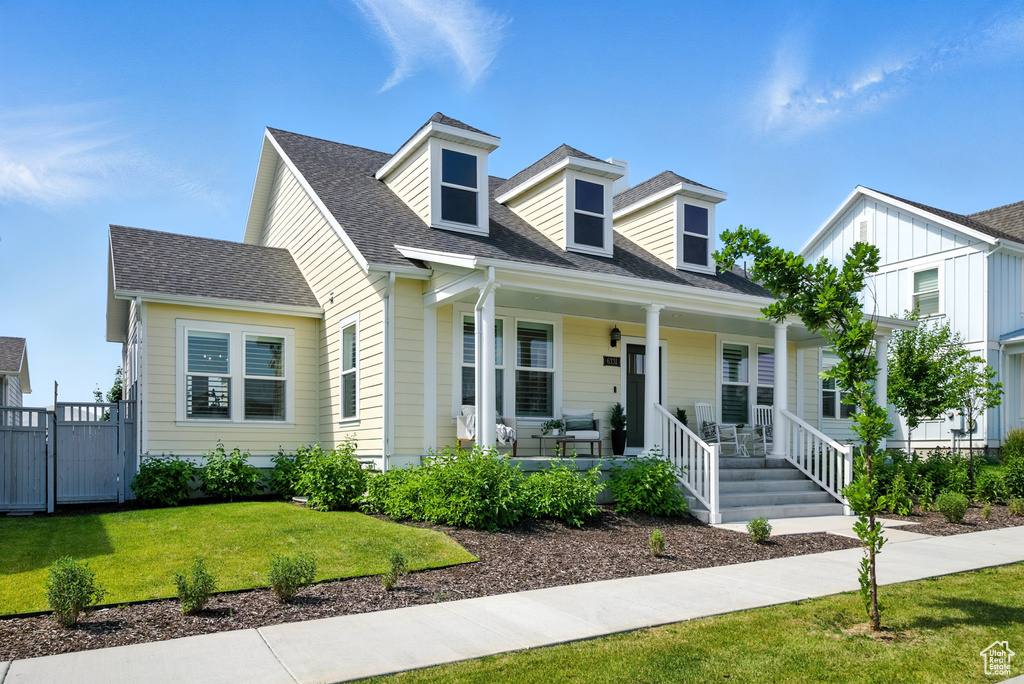 Cape cod-style house with a porch and a shingled roof