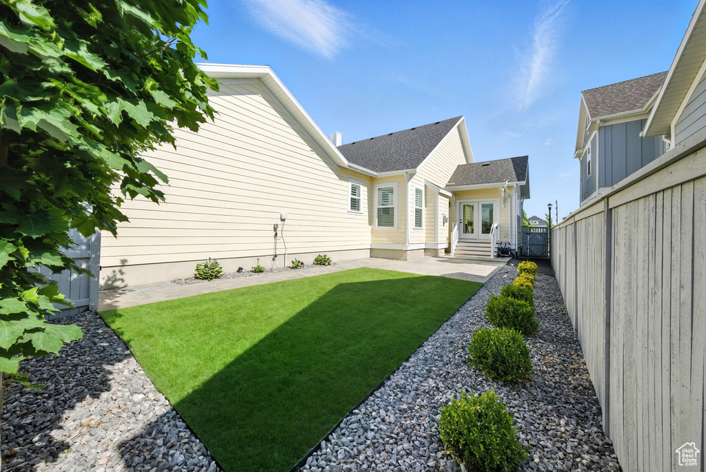 View of yard featuring entry steps, a patio, and french doors
