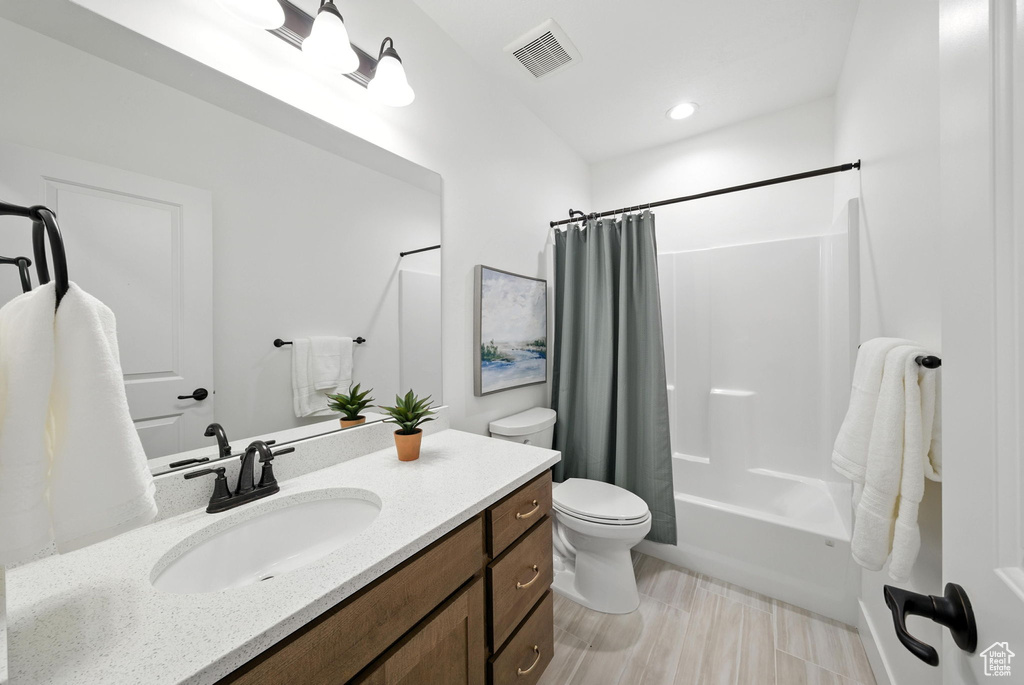 Bathroom with vanity, shower / bath combo with shower curtain, and recessed lighting