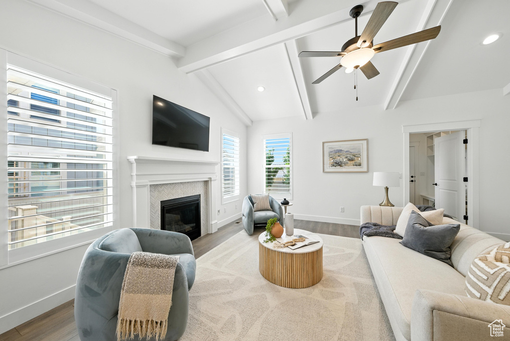 Living room featuring wood finished floors, a ceiling fan, a glass covered fireplace, and recessed lighting