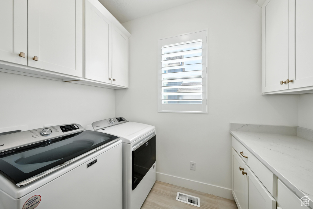 Laundry area featuring washer and dryer and cabinet space
