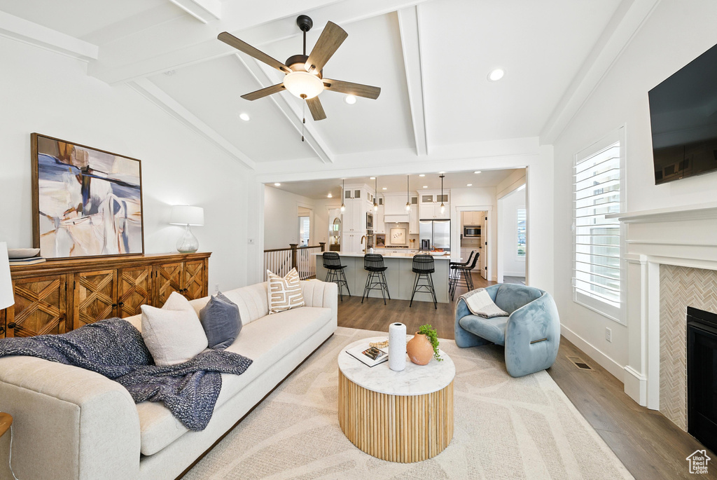 Living area with wood finished floors, a ceiling fan, a fireplace, and recessed lighting