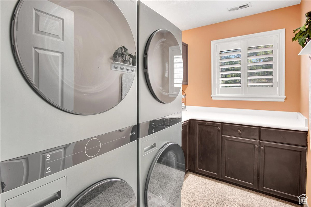 Washroom with stacked washer / drying machine and cabinet space