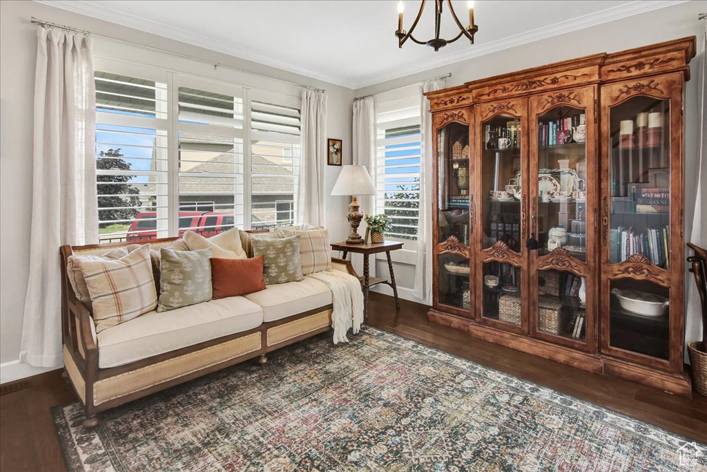 Living area with wood finished floors, a chandelier, and ornamental molding