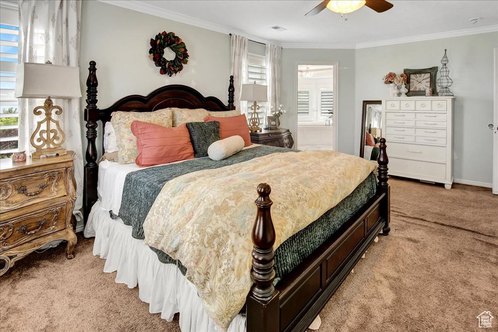 Bedroom with light carpet, ornamental molding, a ceiling fan, and connected bathroom